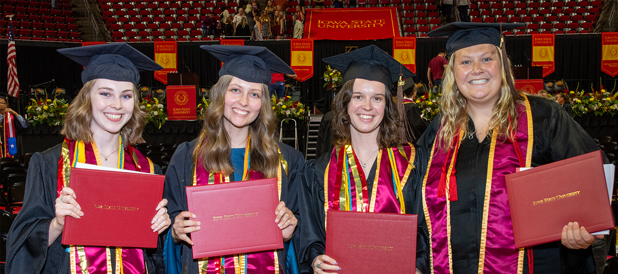 Undergrads pose with diploma covers